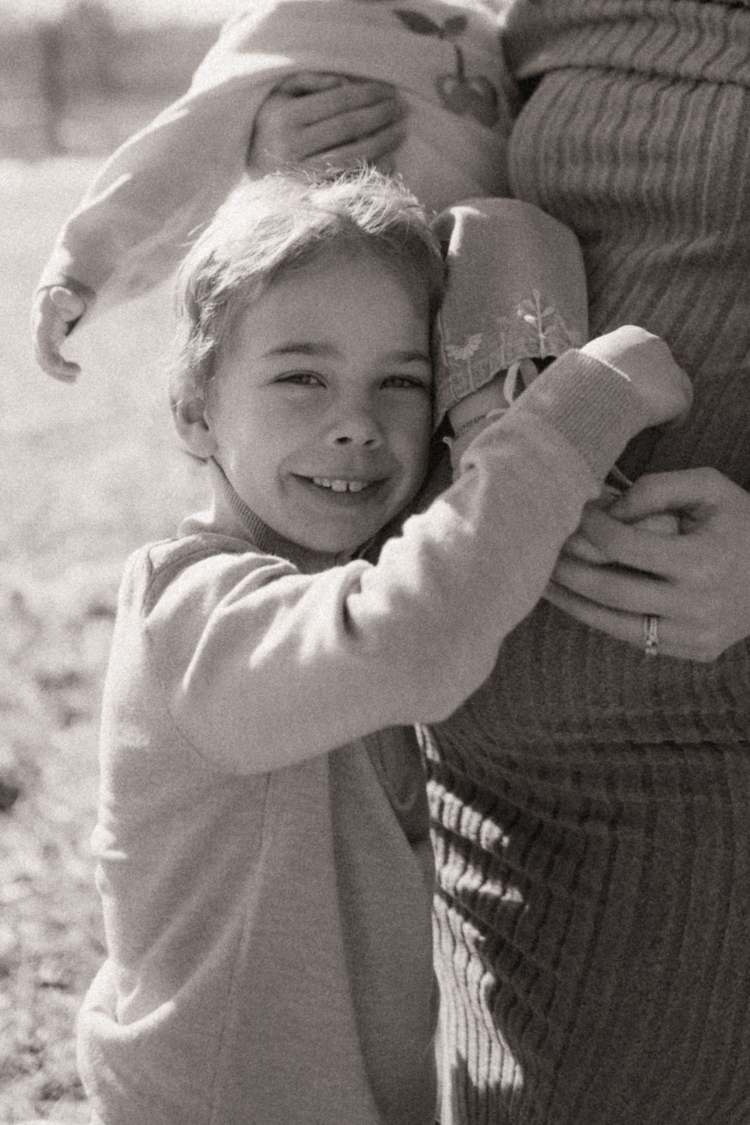 Close-up sequence showing tender moments between parent and child in warm sunlight.