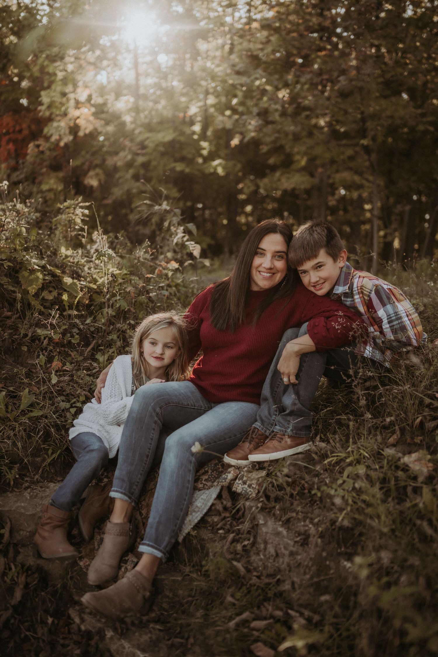 Intimate family moment captured during sunset in autumn woodland setting.