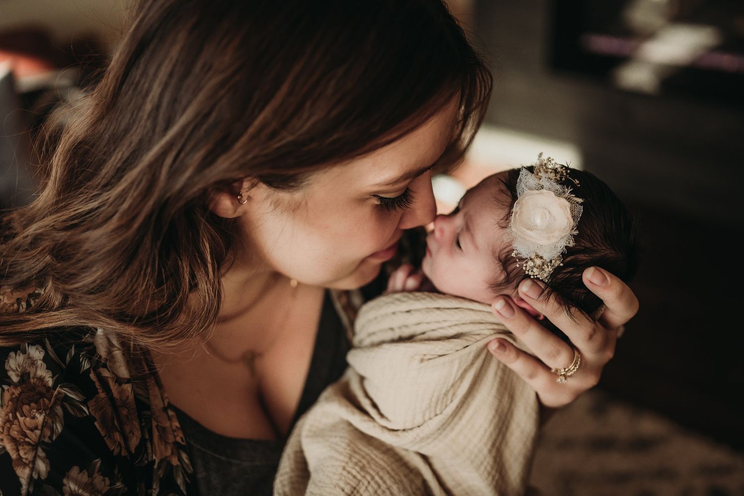 Intimate moment between caregiver and infant in warm natural lighting.