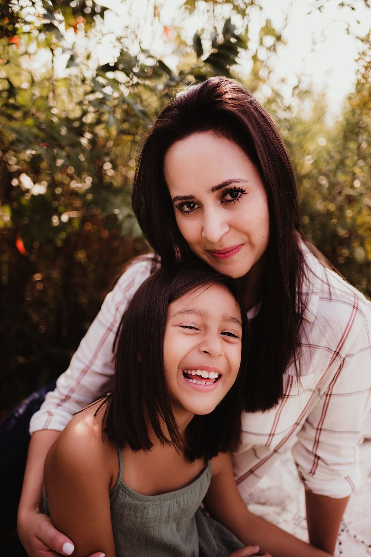 Joyful outdoor photoshoot showing authentic laughter and connection against a natural background.