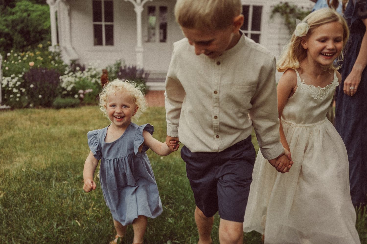 Joyful moment of children running and holding hands in sunny garden.