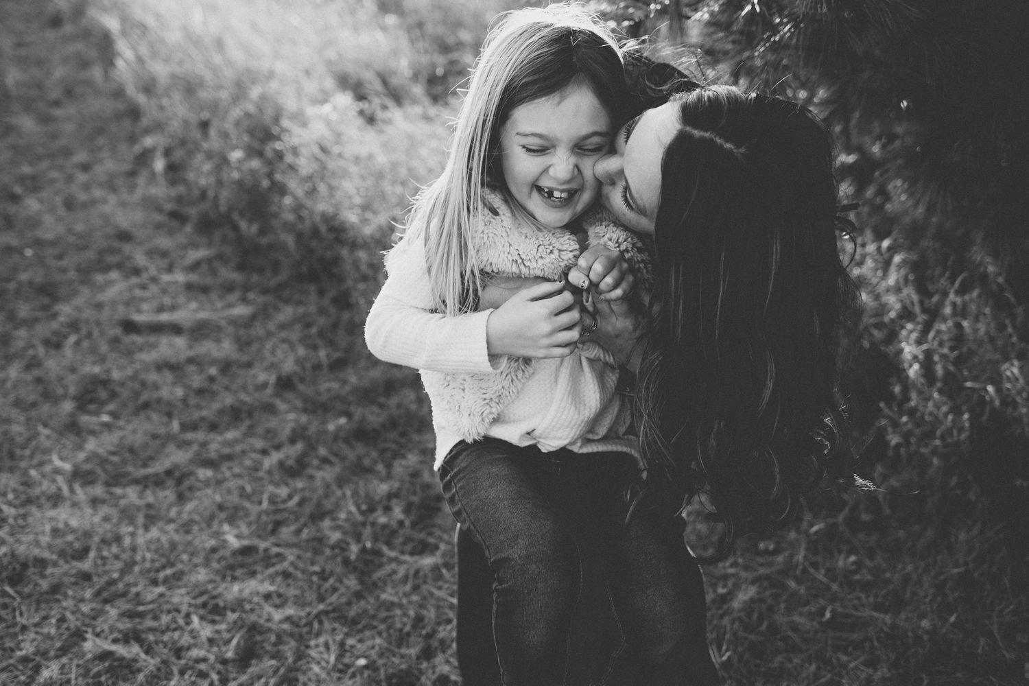 A joyful embrace captured in black and white photography outdoors.