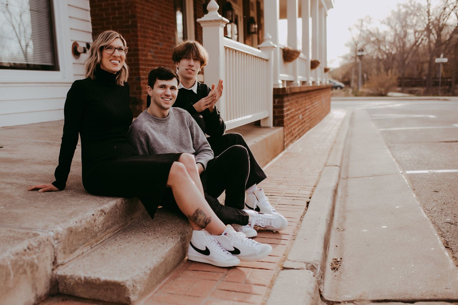 Casual group portrait on brick steps outside a white building with columns.