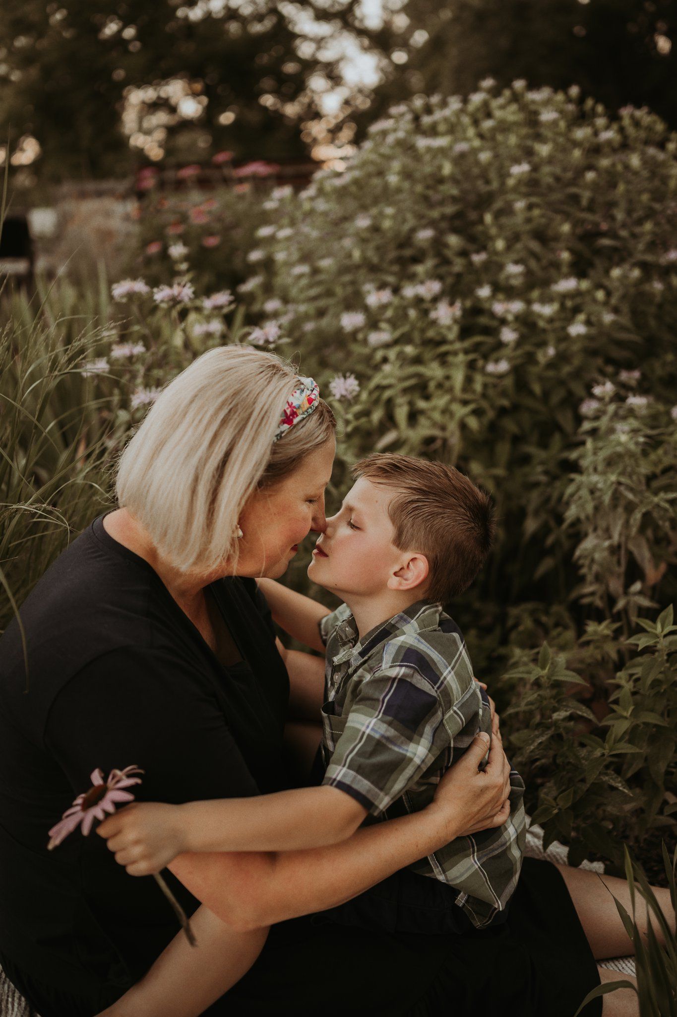 A heartwarming embrace shared amidst blooming wildflowers in a garden setting.