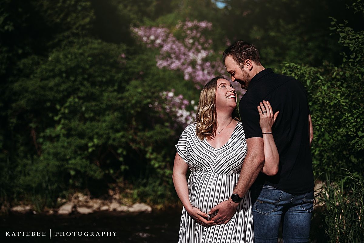 An intimate maternity moment captured outdoors with natural golden lighting.