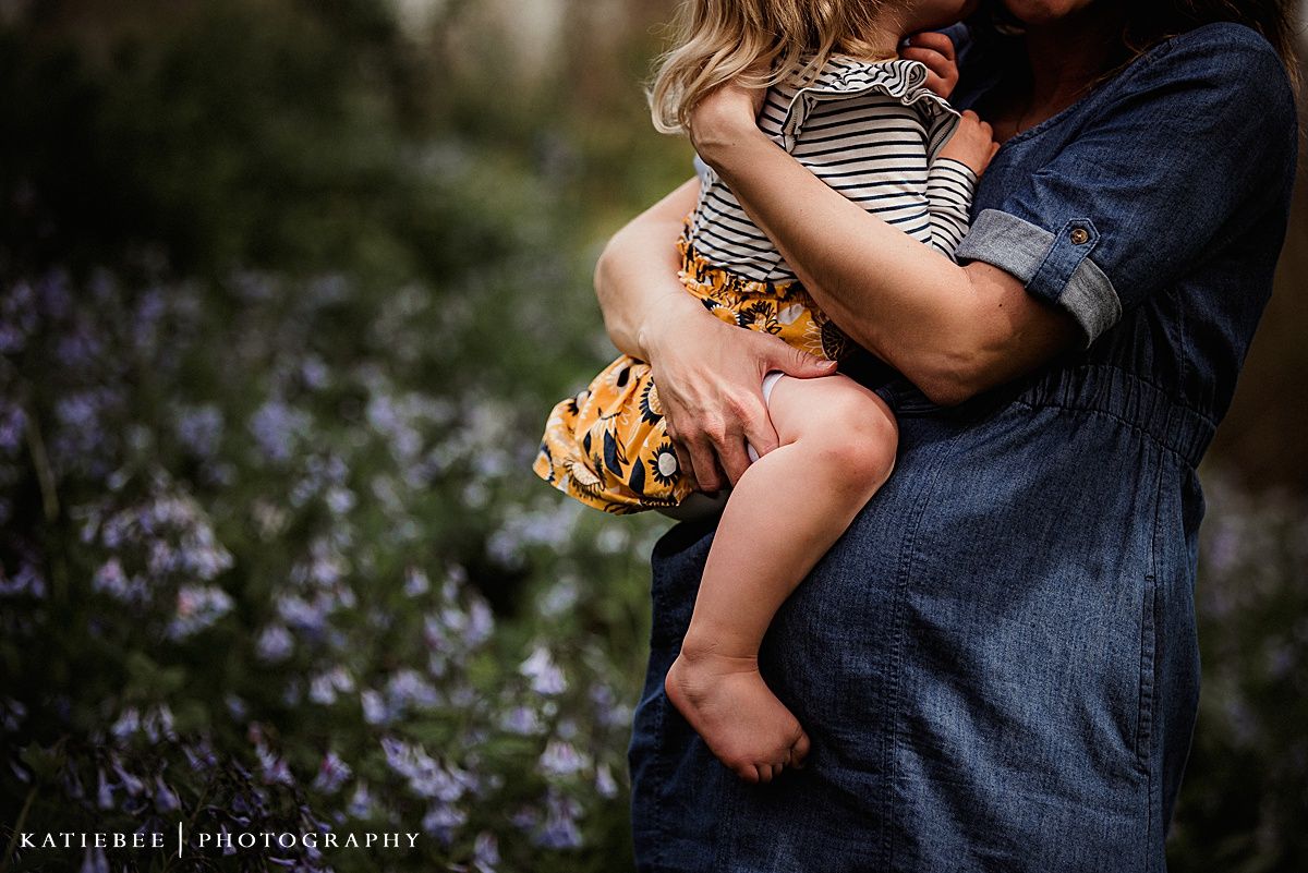 Candid outdoor portrait showing affection amid blooming purple wildflowers.