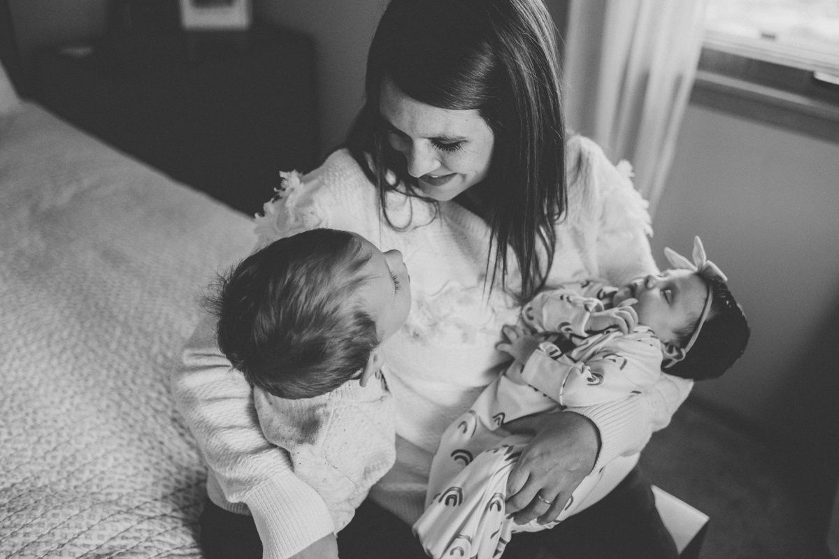 Monochrome capture of tender family bonding moment on bed.