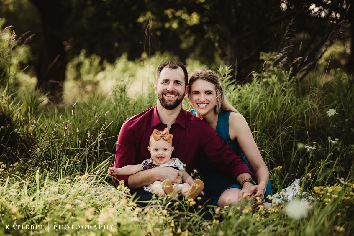 Outdoor family portrait in a wildflower field with burgundy and teal clothing.