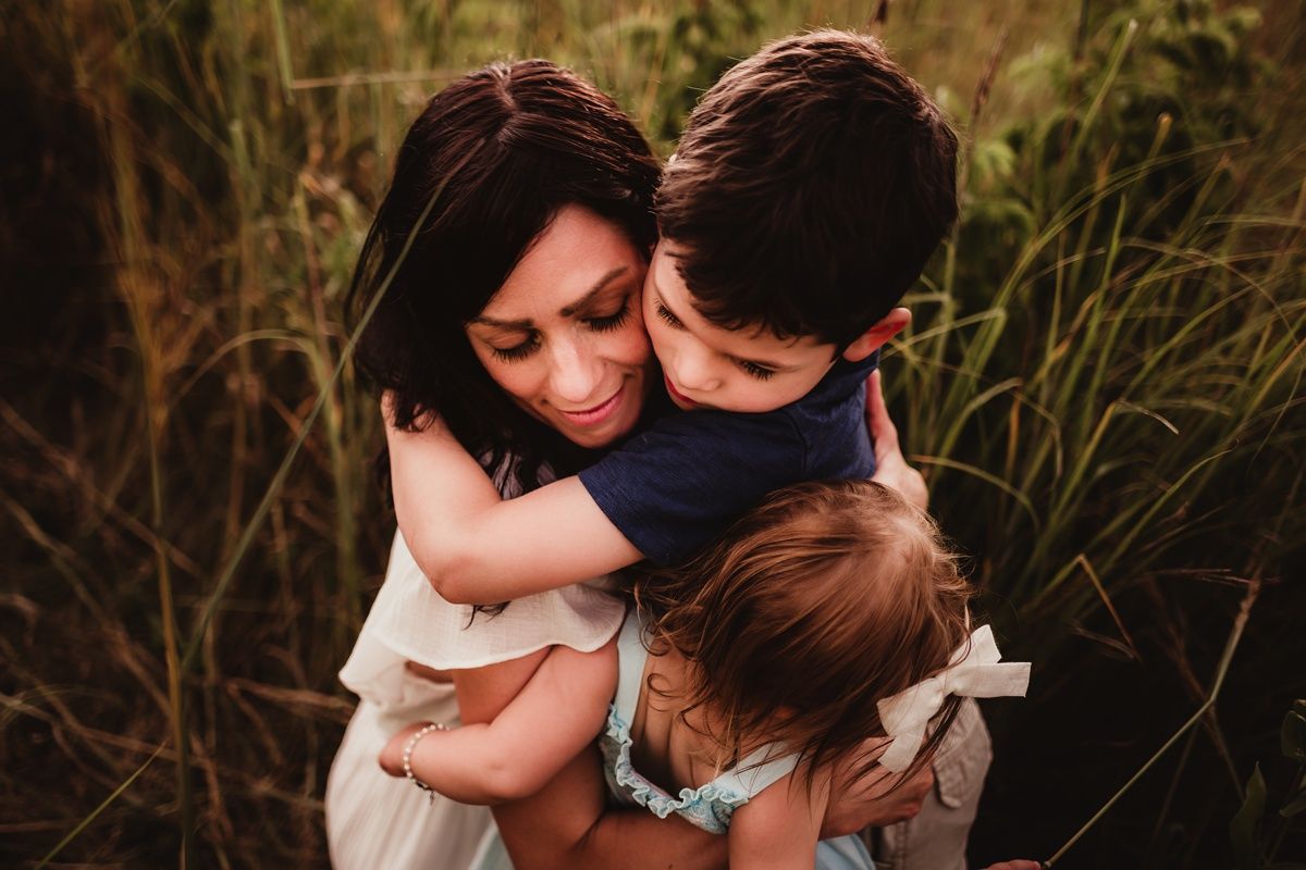 Intimate family embrace captured in natural outdoor setting.