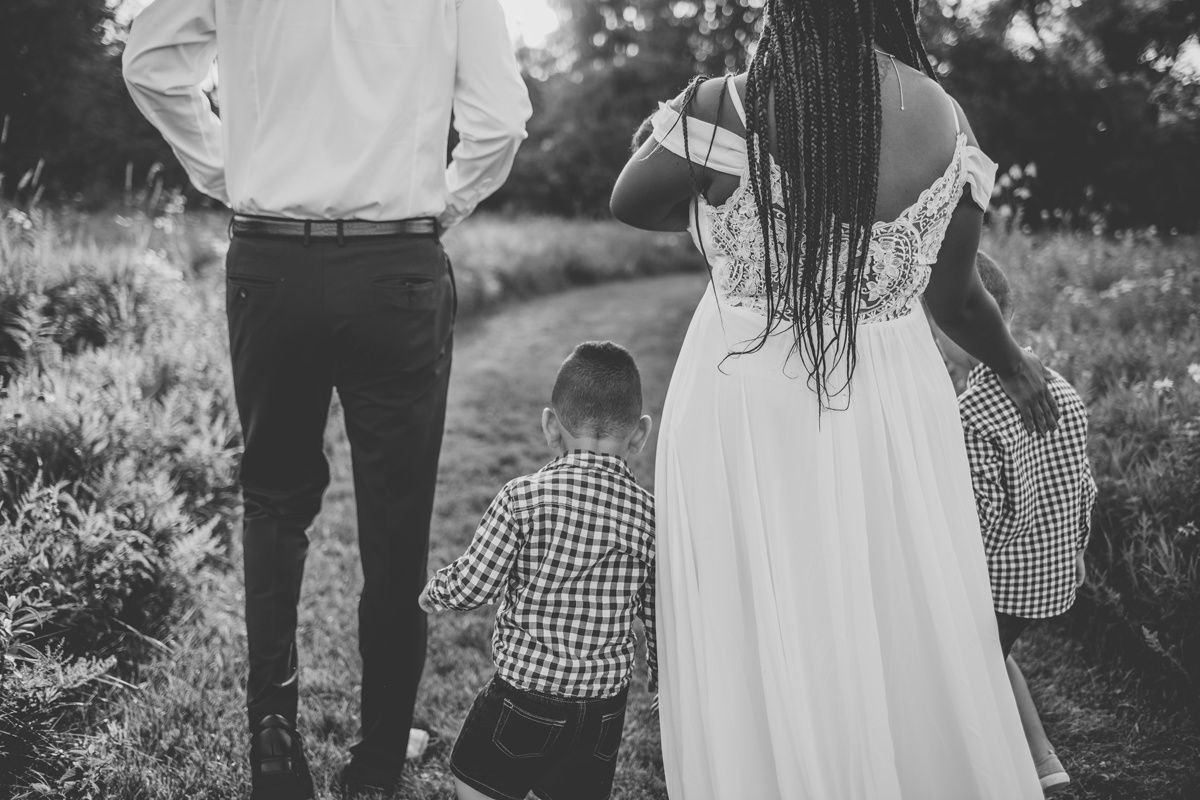 Family in coordinated black and white outfits sharing a candid moment outdoors.