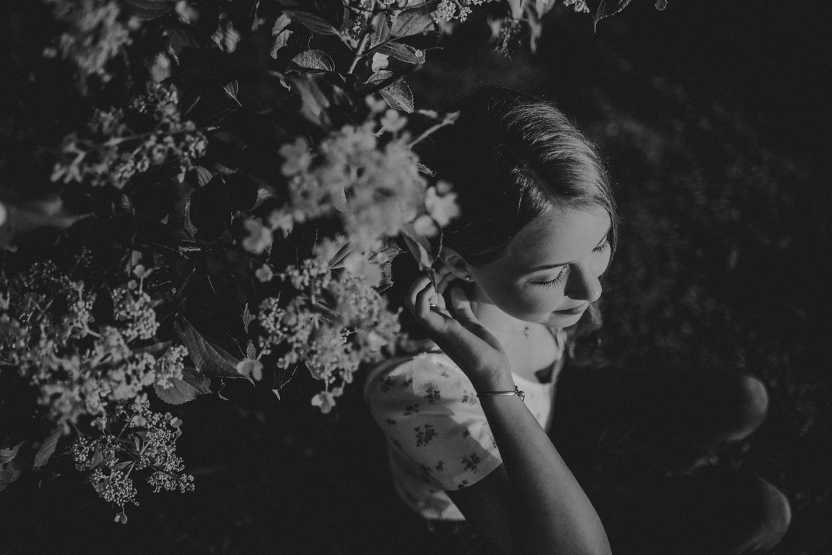 A dramatic black and white portrait with blooming branches.