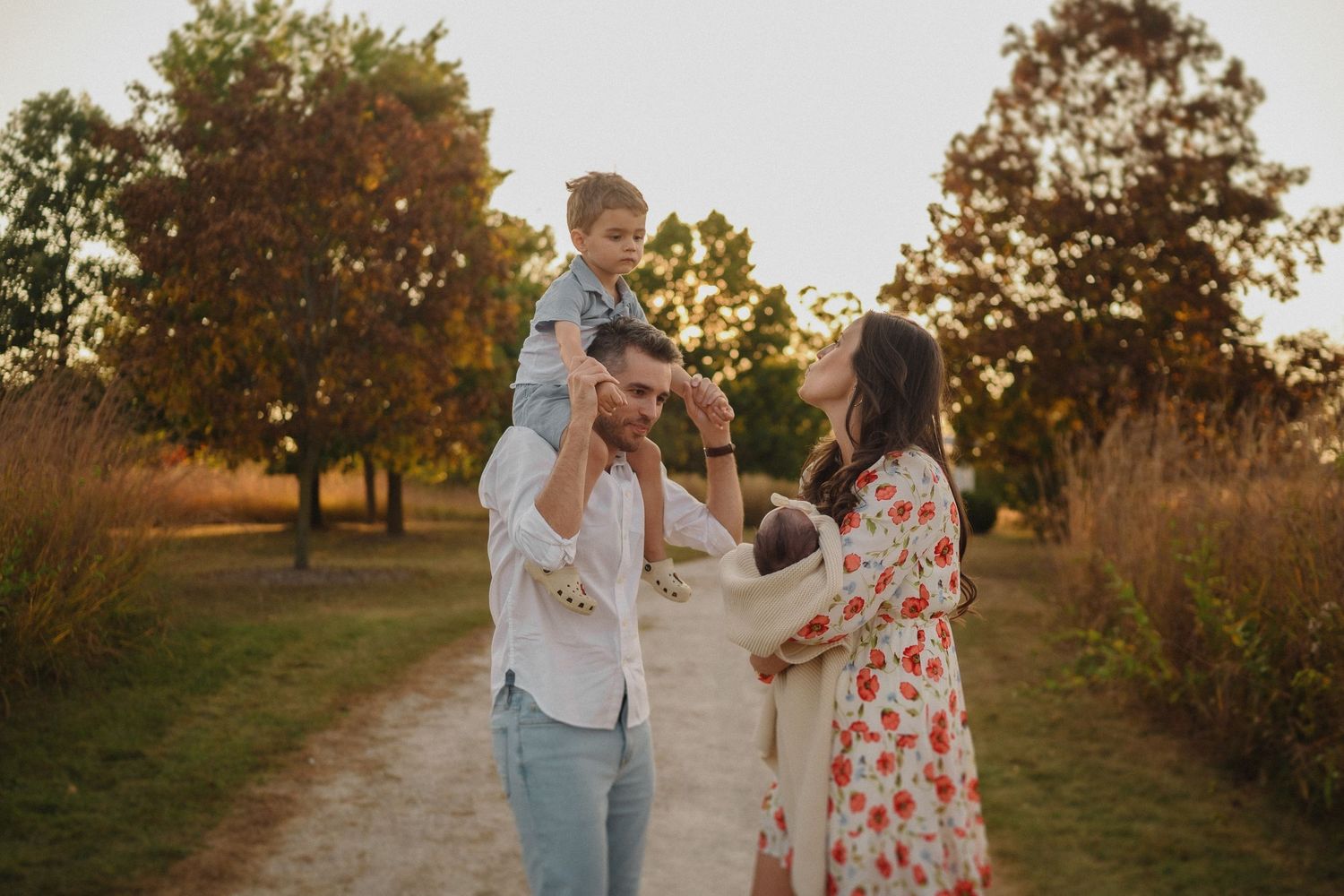 Family sharing tender moment on nature path during golden hour.