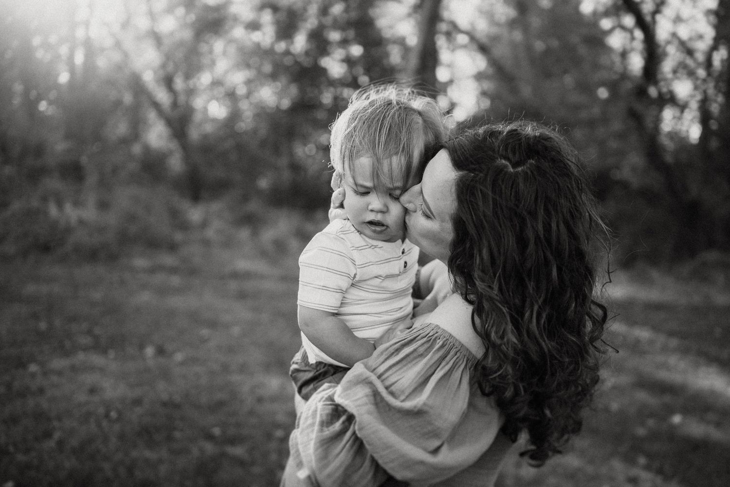 Black and white portrait capturing an intimate moment outdoors.