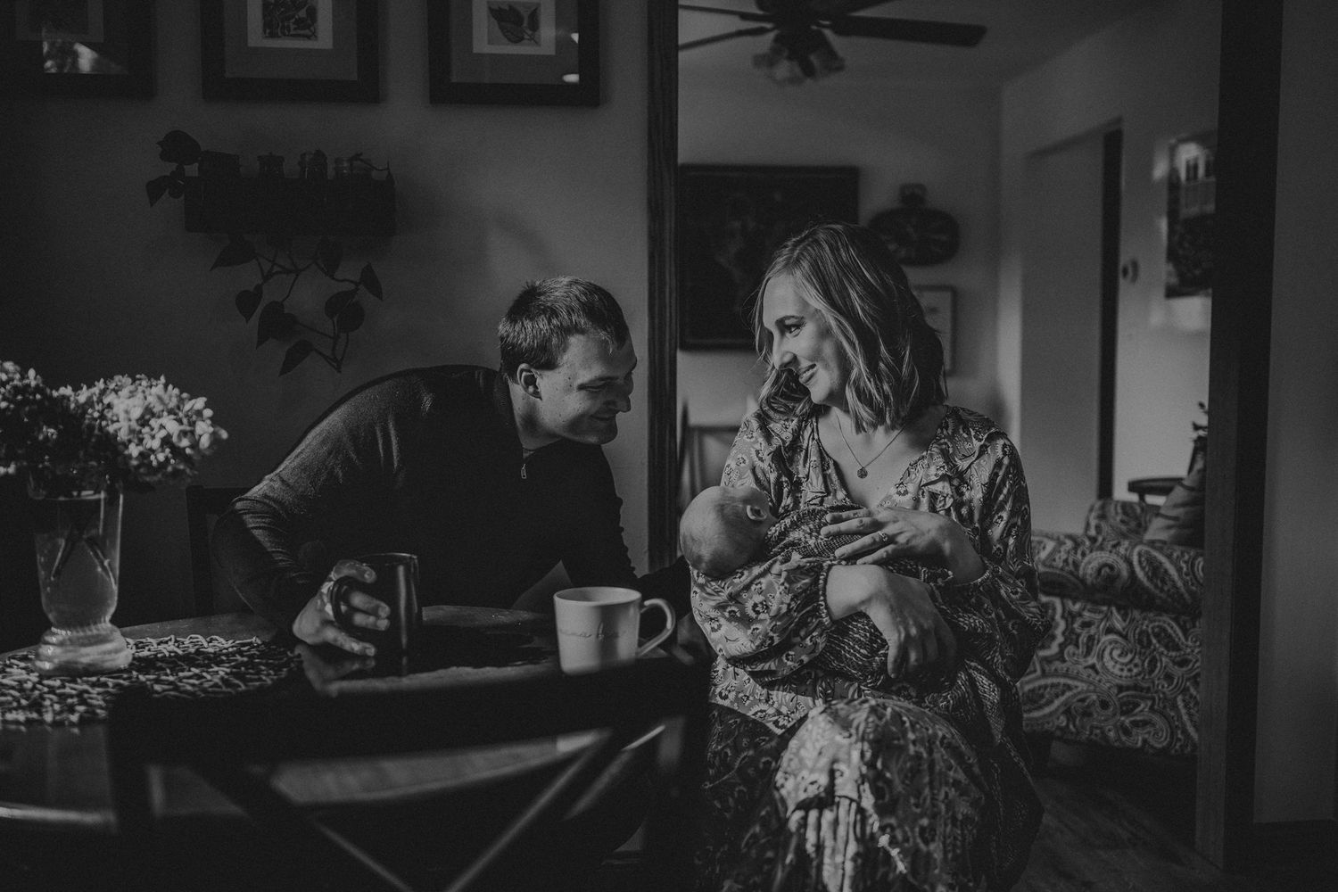 Intimate black and white photo of couple sharing coffee at dining table.