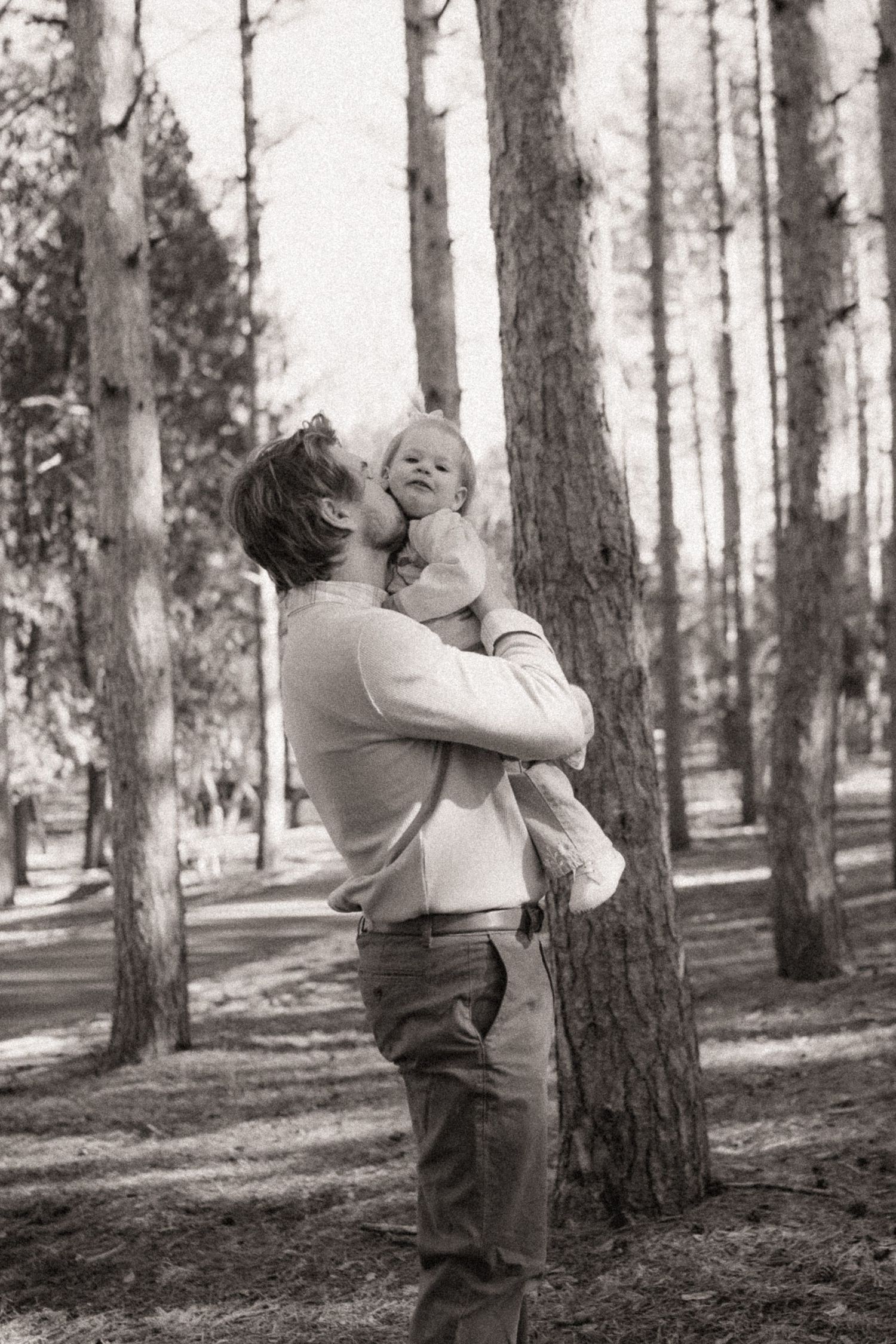 A playful sequence of interactions among family members in a sunlit forest setting.
