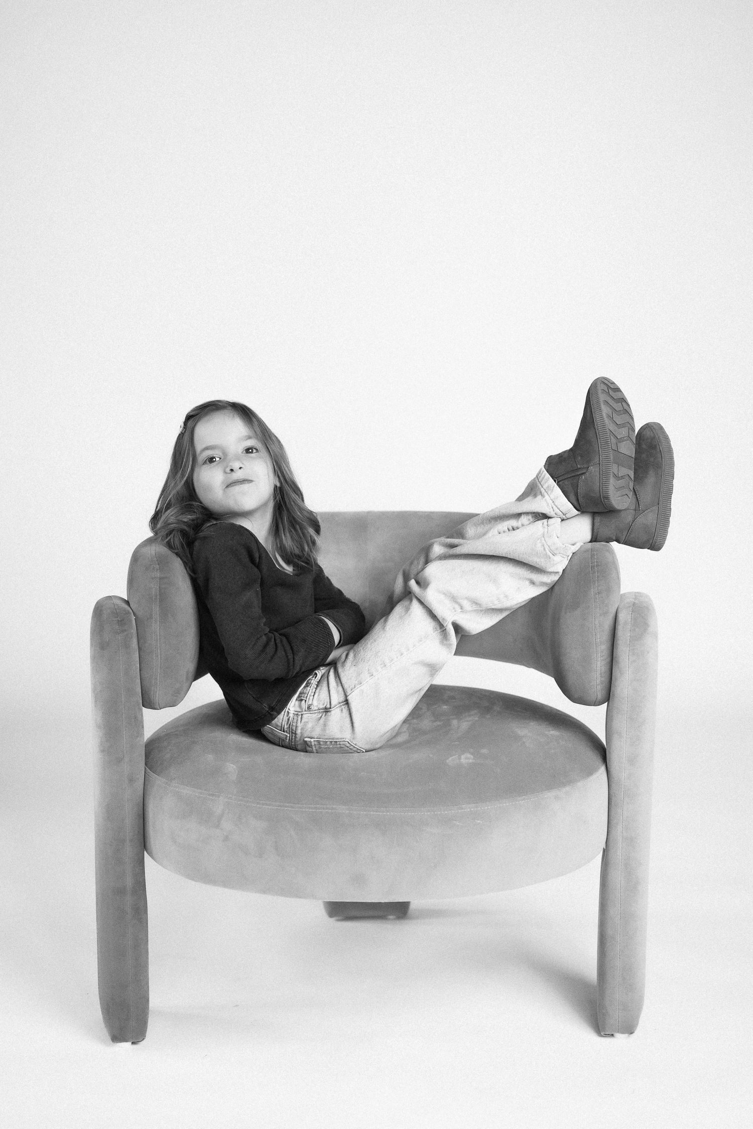 Black and white series of someone lounging and rolling on a modern curved chair.