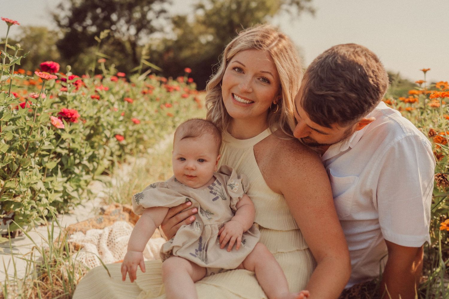 A loving family moment captured among blooming wildflowers at sunset.