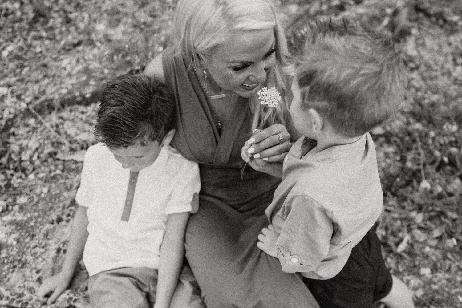 An intimate black and white portrait of a loving family moment outdoors.