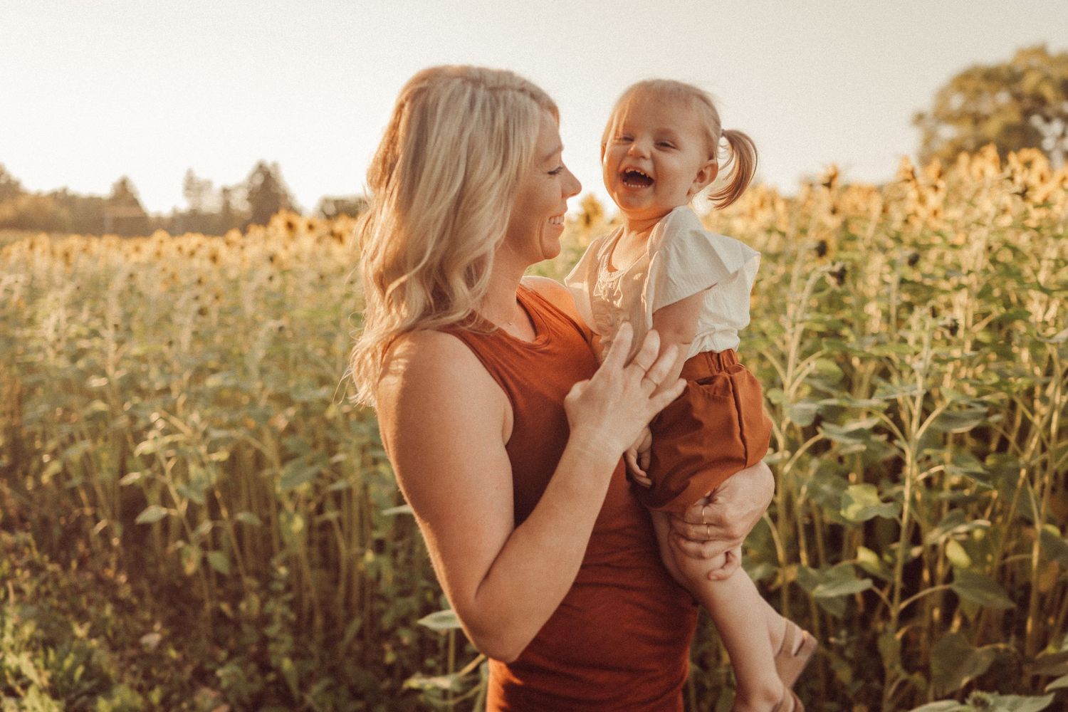 Heartwarming sunset portrait amidst towering sunflowers and natural flora.