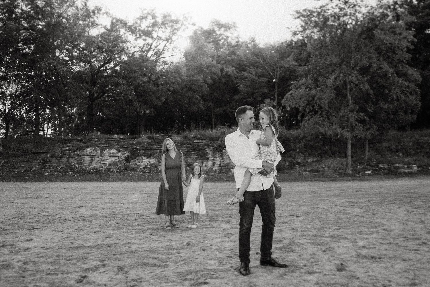 A family gathering in black and white photography at dusk in an open field.
