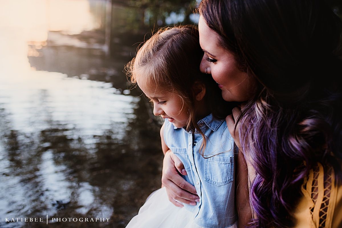 An intimate candid moment shared between two people at sunset by the water.