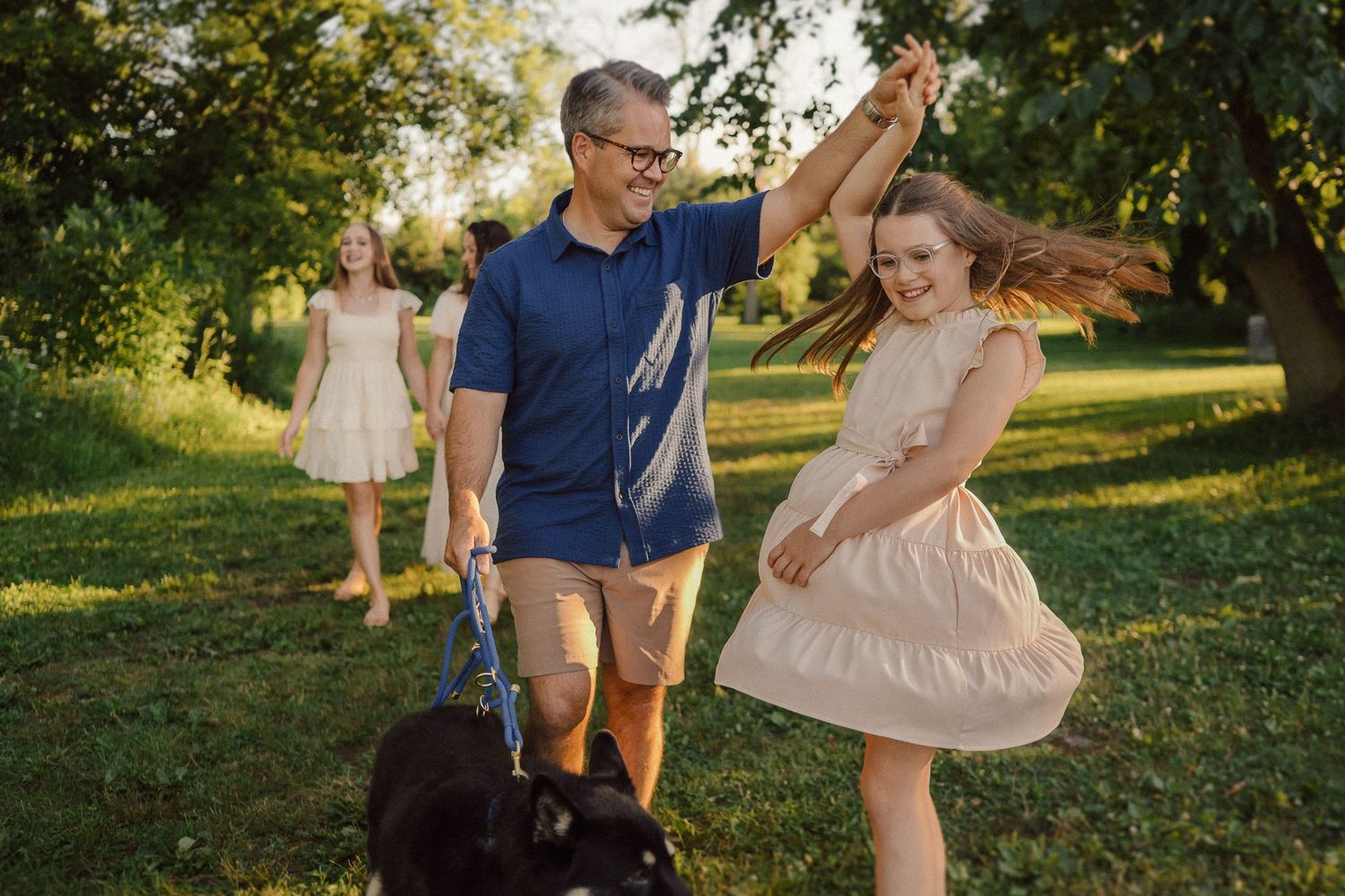 A fun dancing scene captured in a park with golden sunlight filtering through trees.