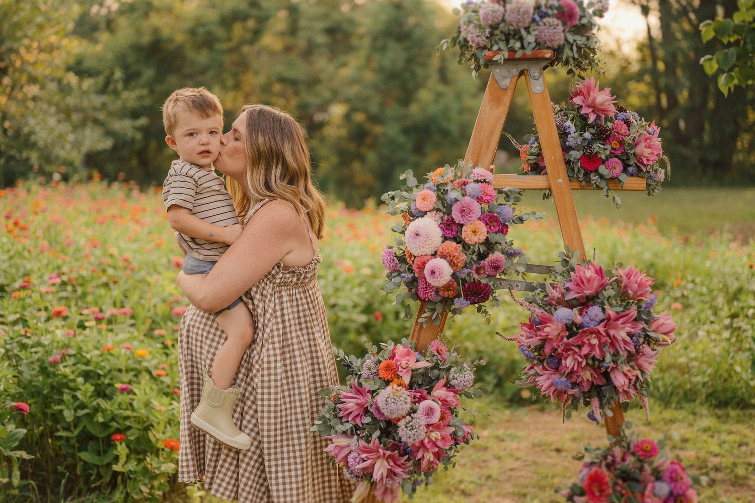 A beautiful outdoor family photoshoot among vibrant flowers and floral arrangements in a garden setting.
