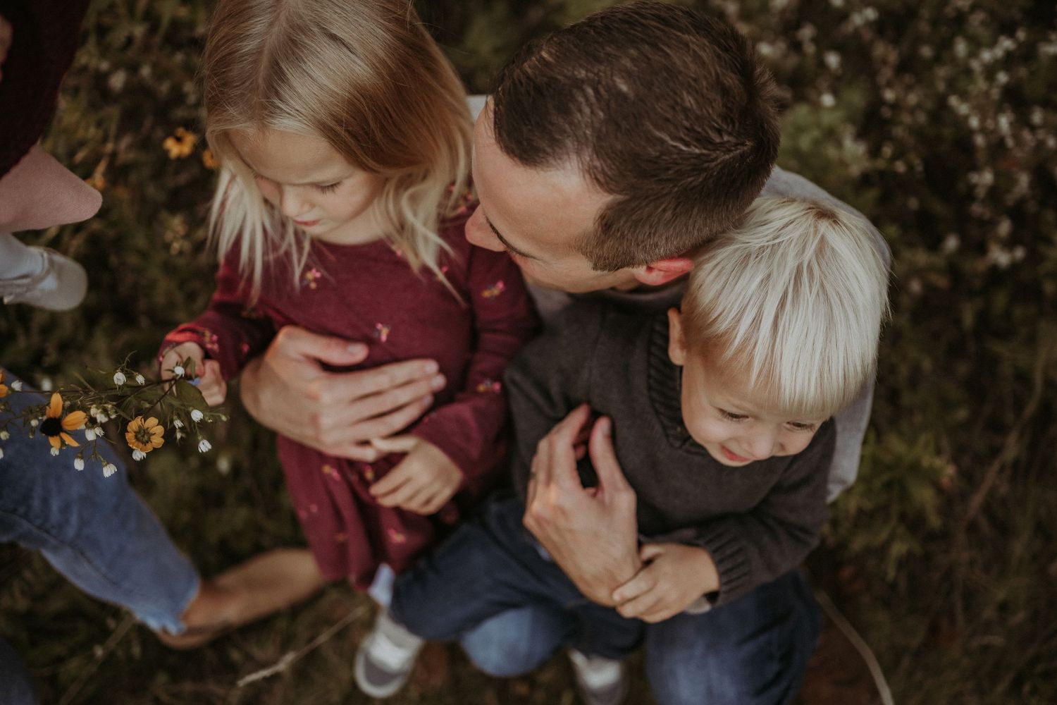 An intimate family moment captured outdoors during golden hour.