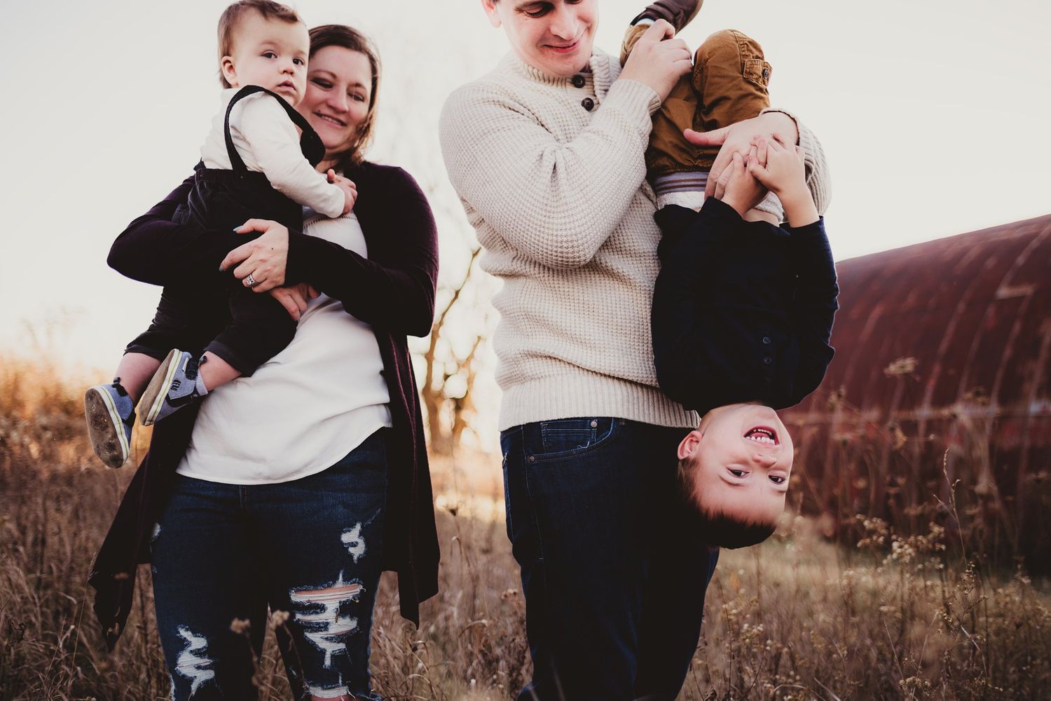 Playful family portrait outdoors with everyone laughing and being silly.