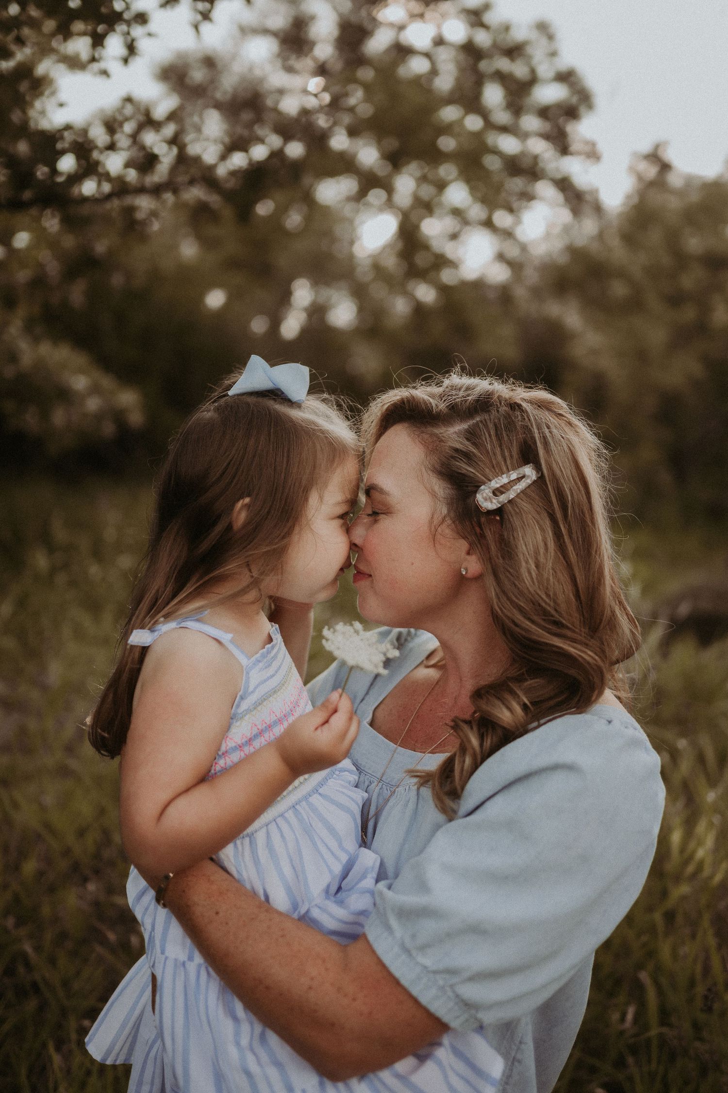 An intimate tender moment shared between two people in a sunlit field.