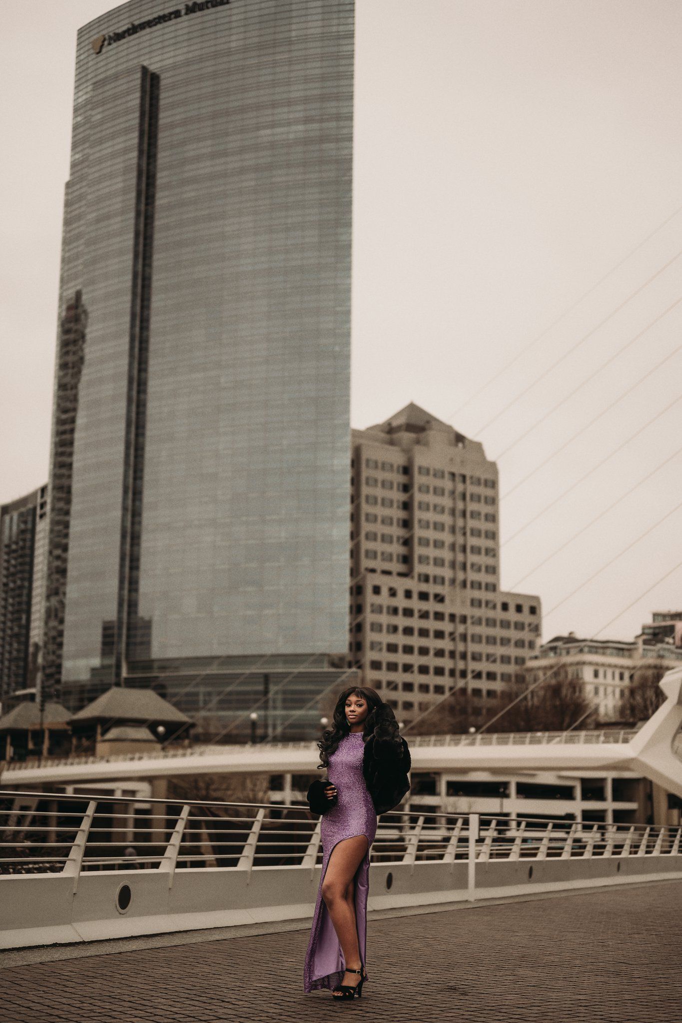 Fashion photography with urban skyline featuring glass buildings and modern architecture.