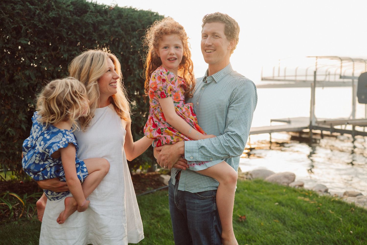 A happy family shares a candid moment together by the waterfront at sunset.