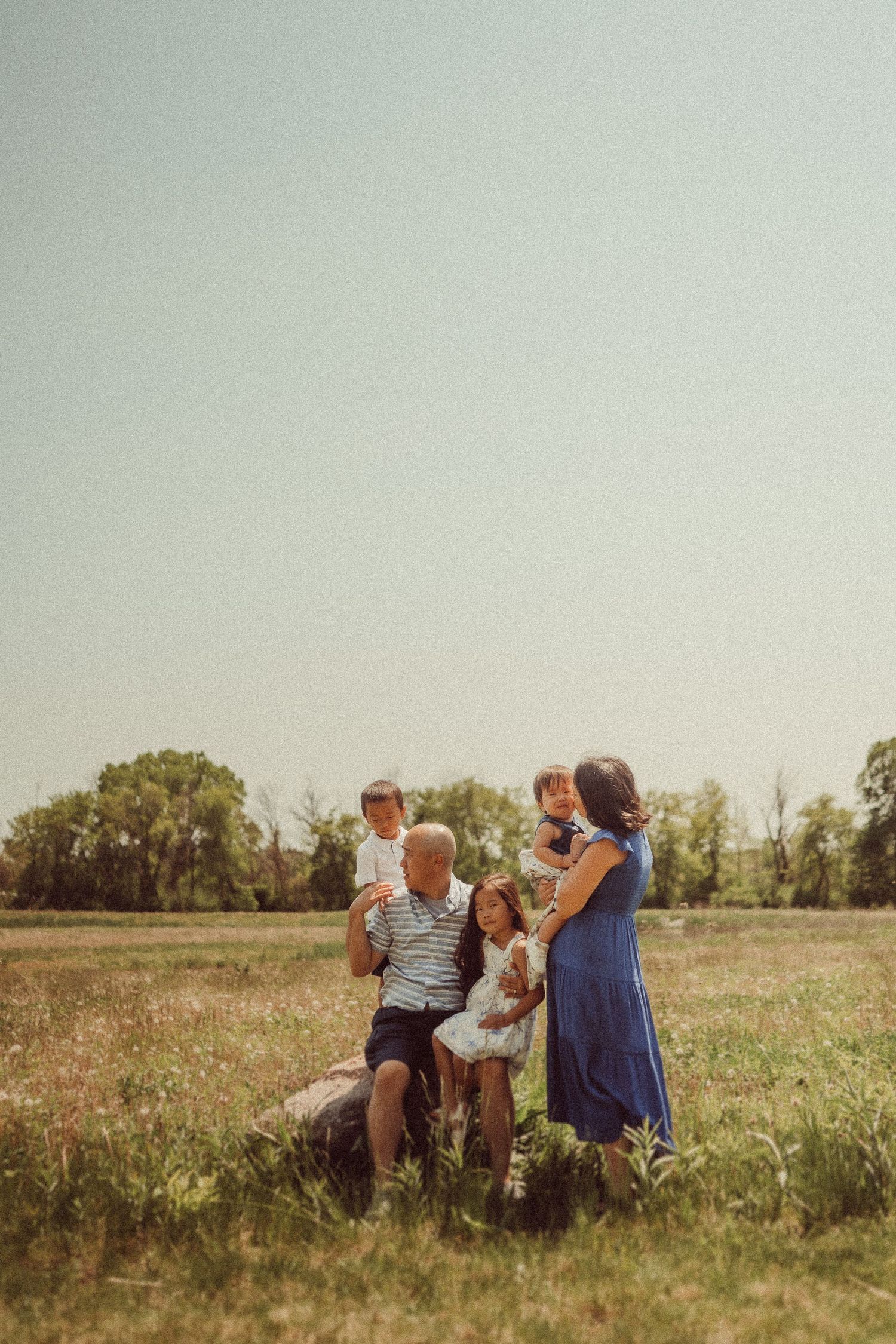Family enjoying quality time together in a sunny meadow.