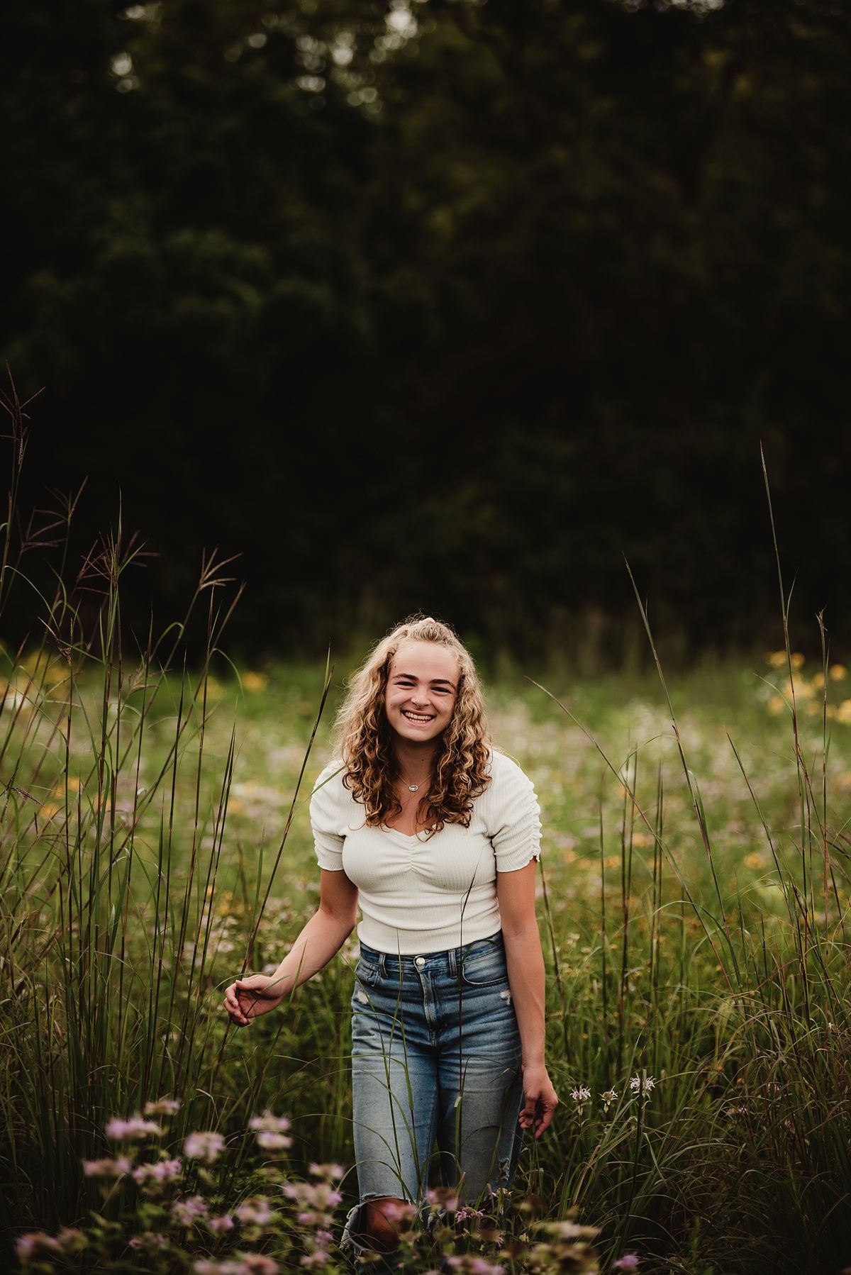 Casual summer portrait in a natural meadow setting with wildflowers.