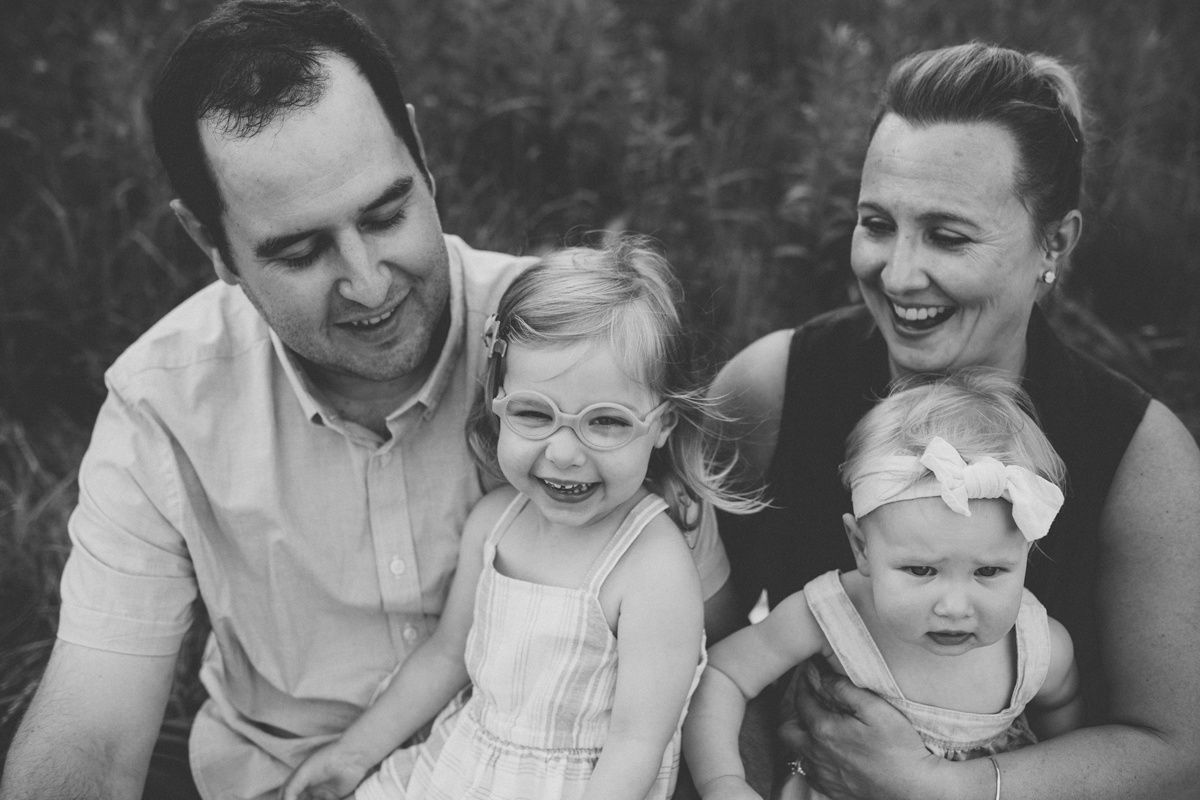 A candid black and white family portrait showing genuine emotions.