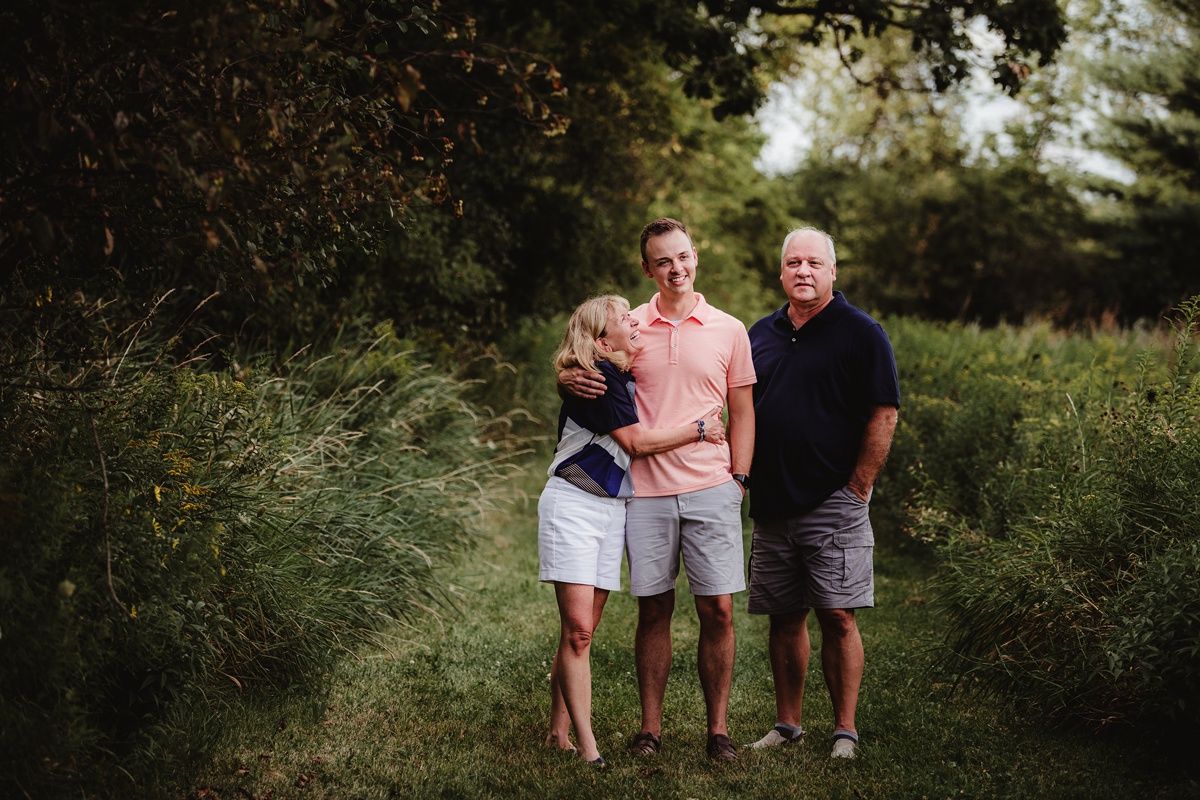 Natural outdoor family portrait in a lush green setting.