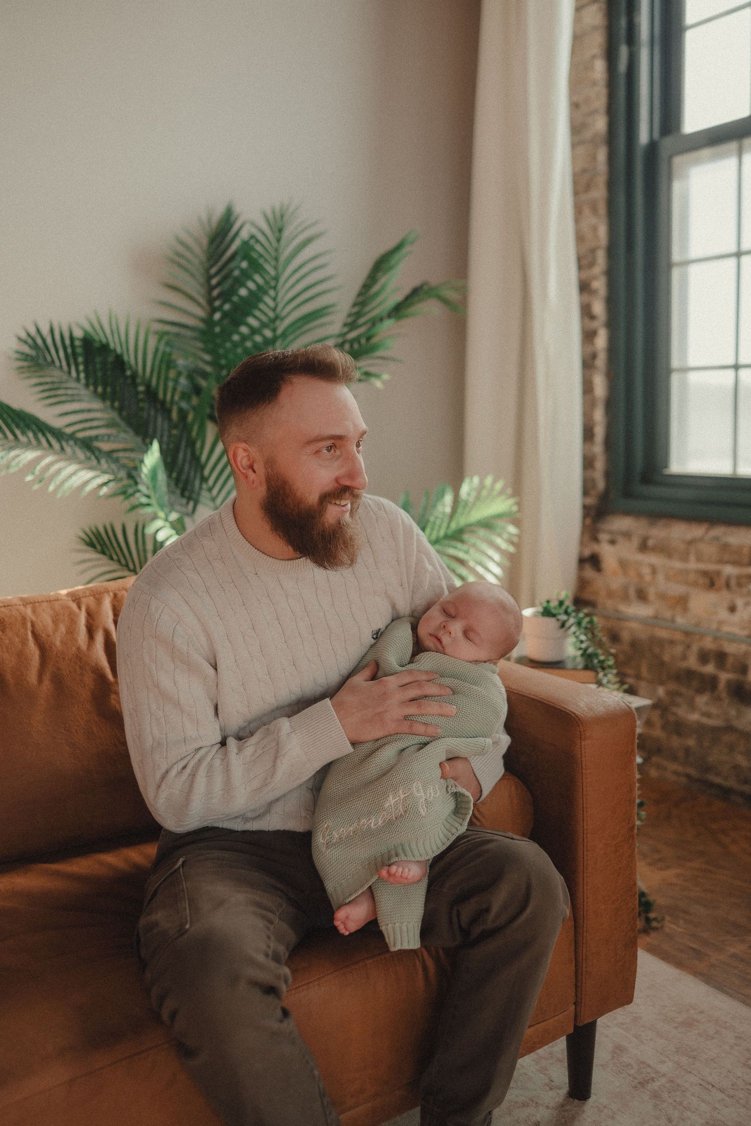 Series showing tender moments on brown leather couch with indoor plants in background.