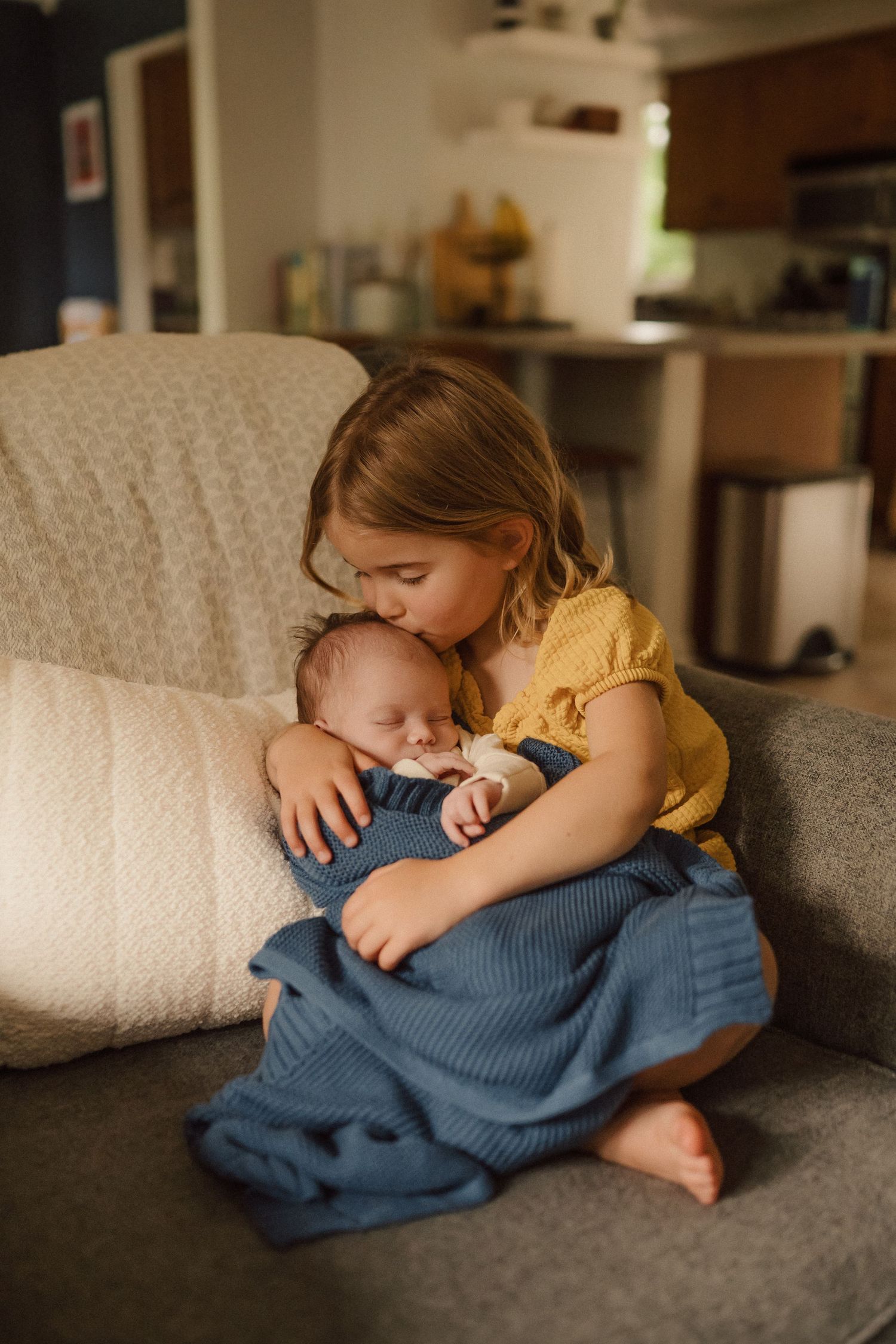 A series of intimate photos showing a tender moment of rest and cuddles on a gray couch.