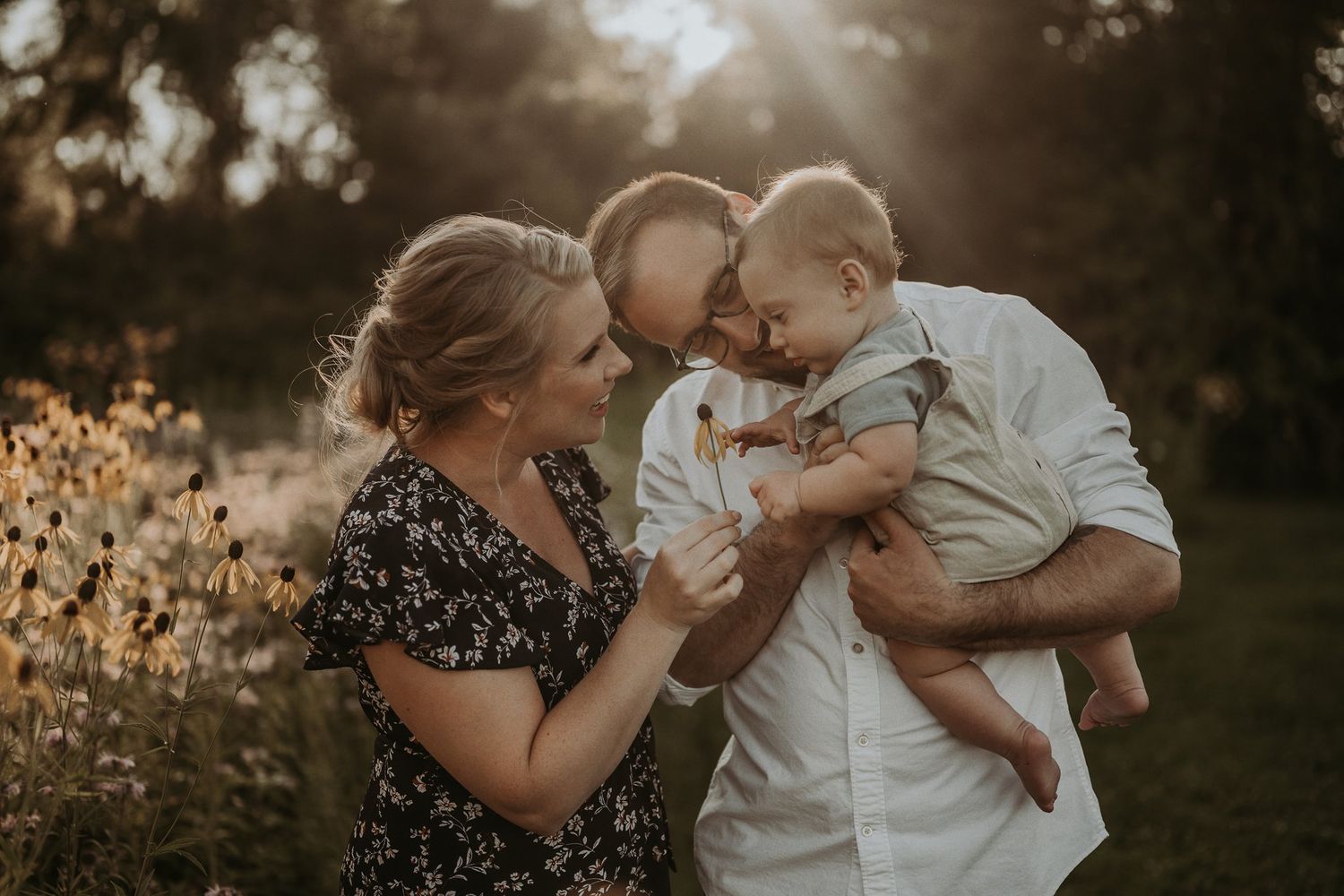 Family shares loving kisses and embraces in golden evening light.