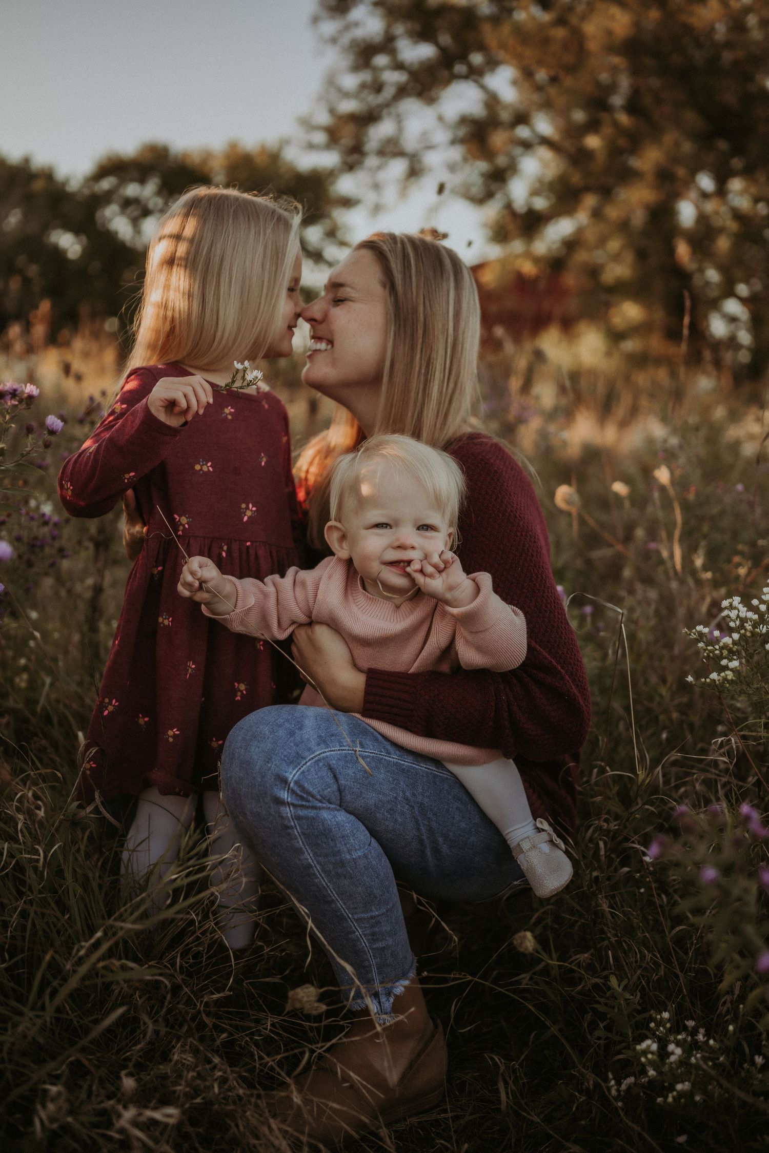 A heartwarming family moment captured in a wildflower field during golden hour.