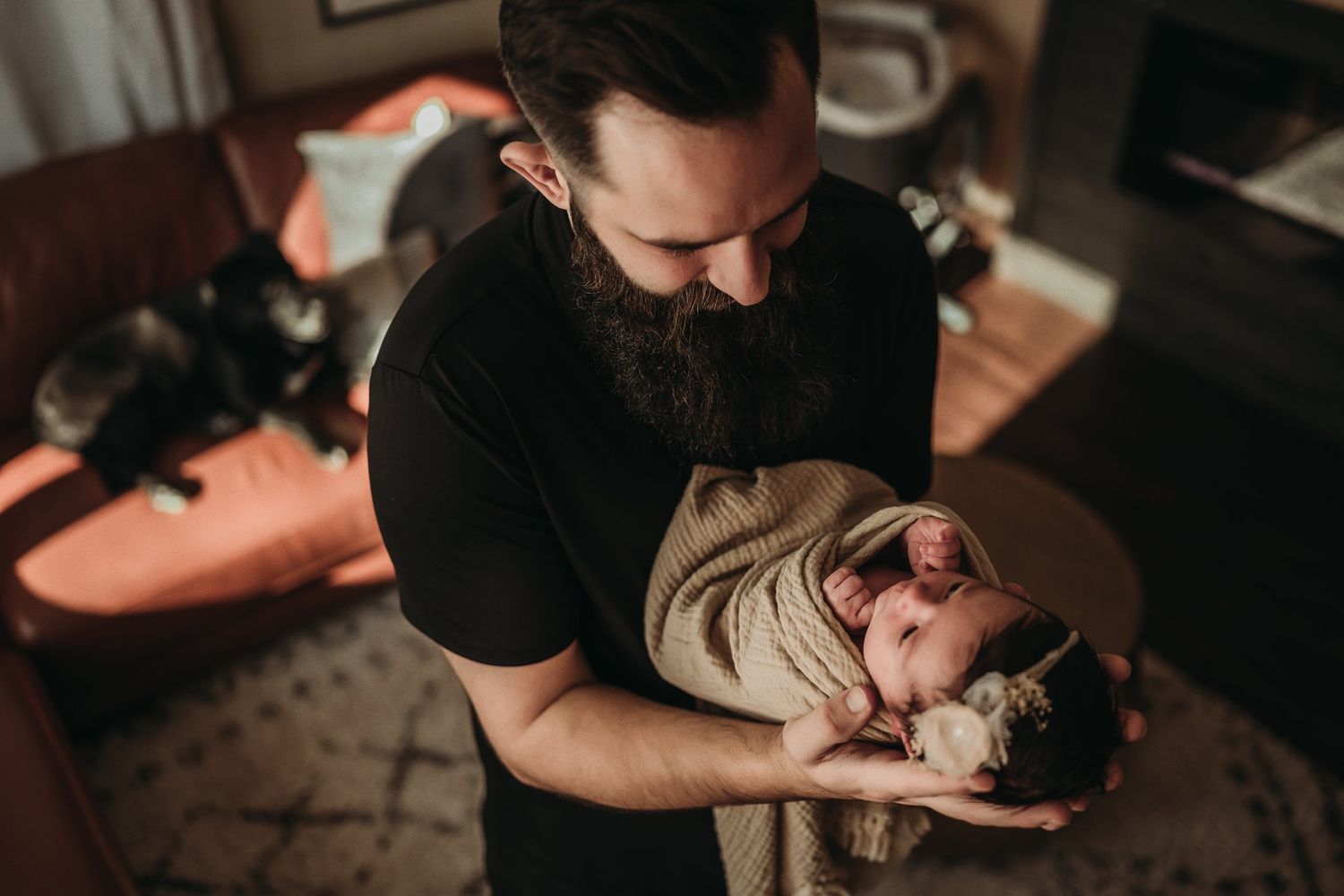 Intimate family moment captured in warm tones as infant is held close.