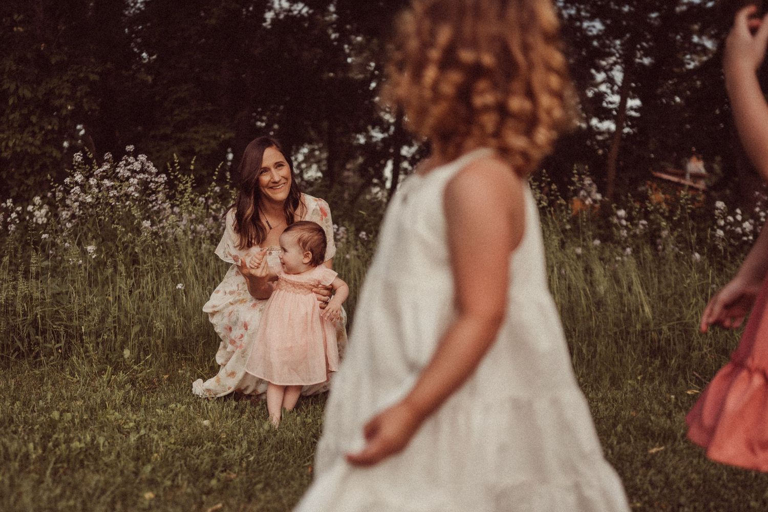A dreamy outdoor portrait session with people in light dresses among wildflowers.