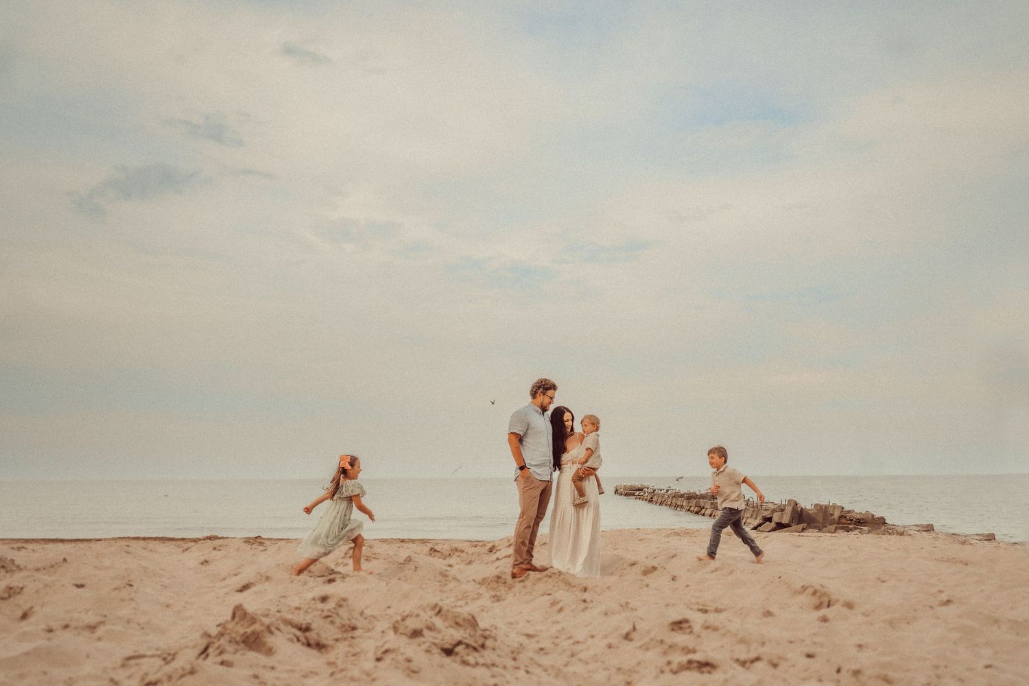 People enjoying a sunny day on sandy beach with ocean in background.