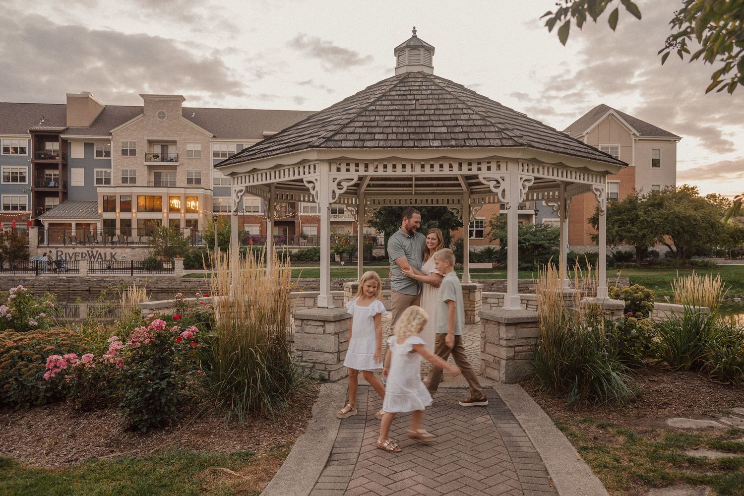 Couple shares romantic moments at sunset across multiple outdoor locations with gazebos and gardens.