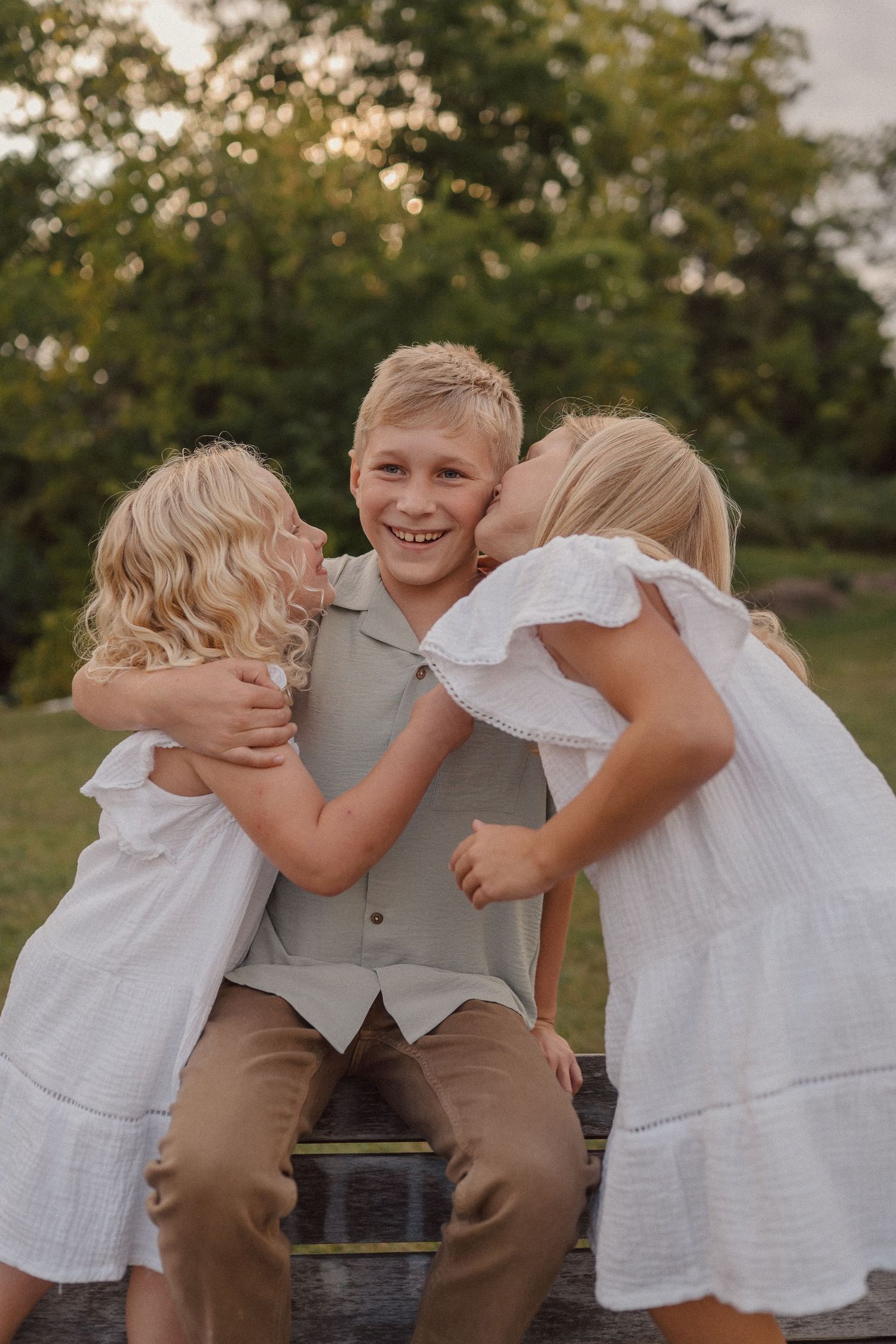 Sweet candid moments between siblings playing together outdoors during golden hour.