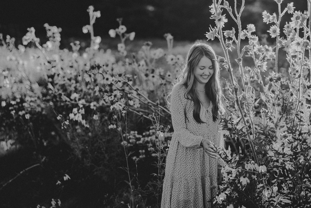 Black and white portrait in a blooming wildflower meadow wearing a flowing dress.