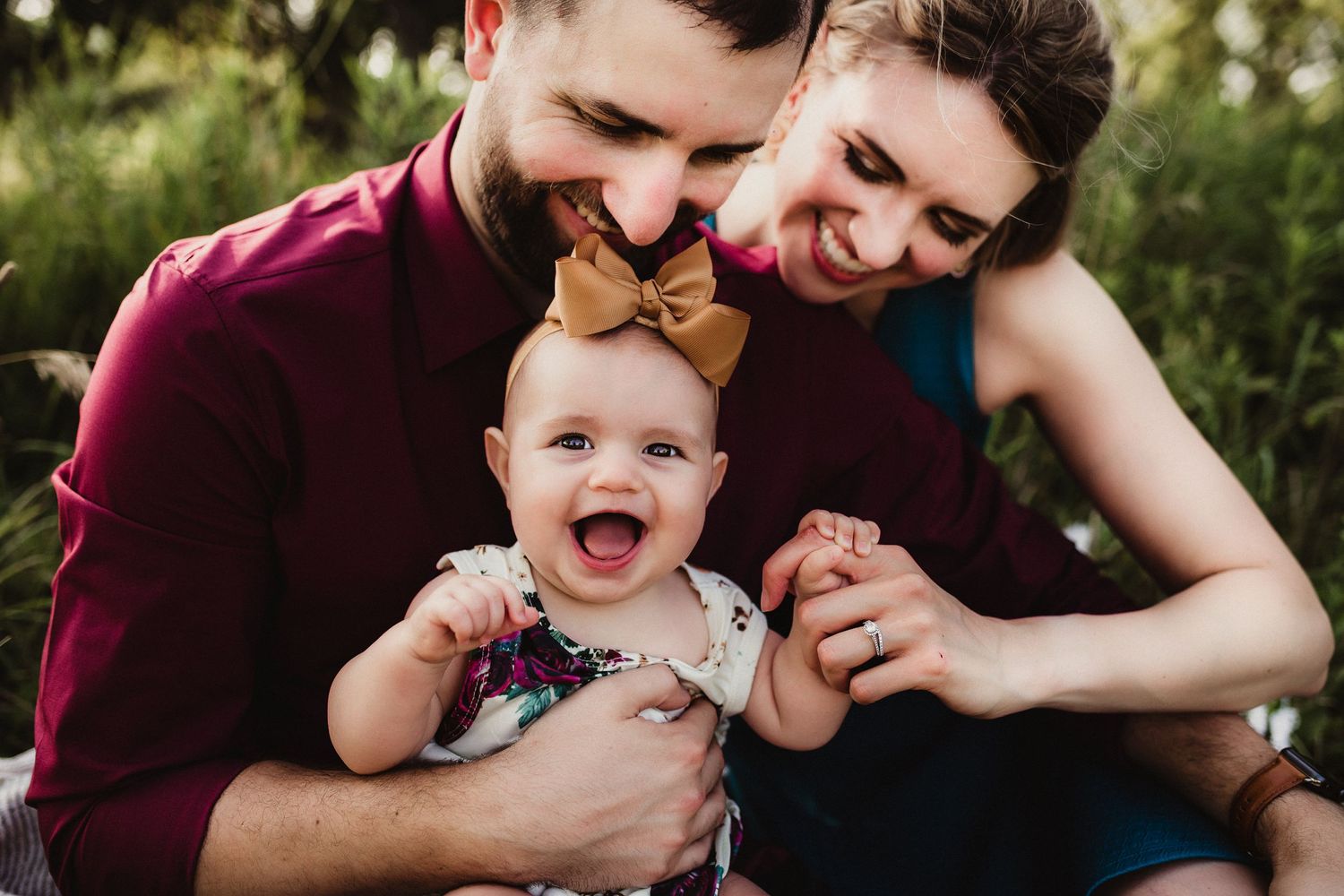 Close-up portrait of family members laughing together outdoors.