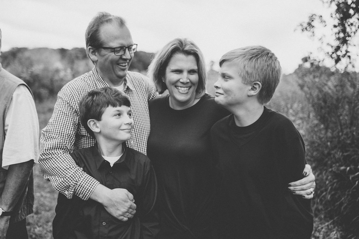 Black and white candid family portrait showing warm interaction outdoors.