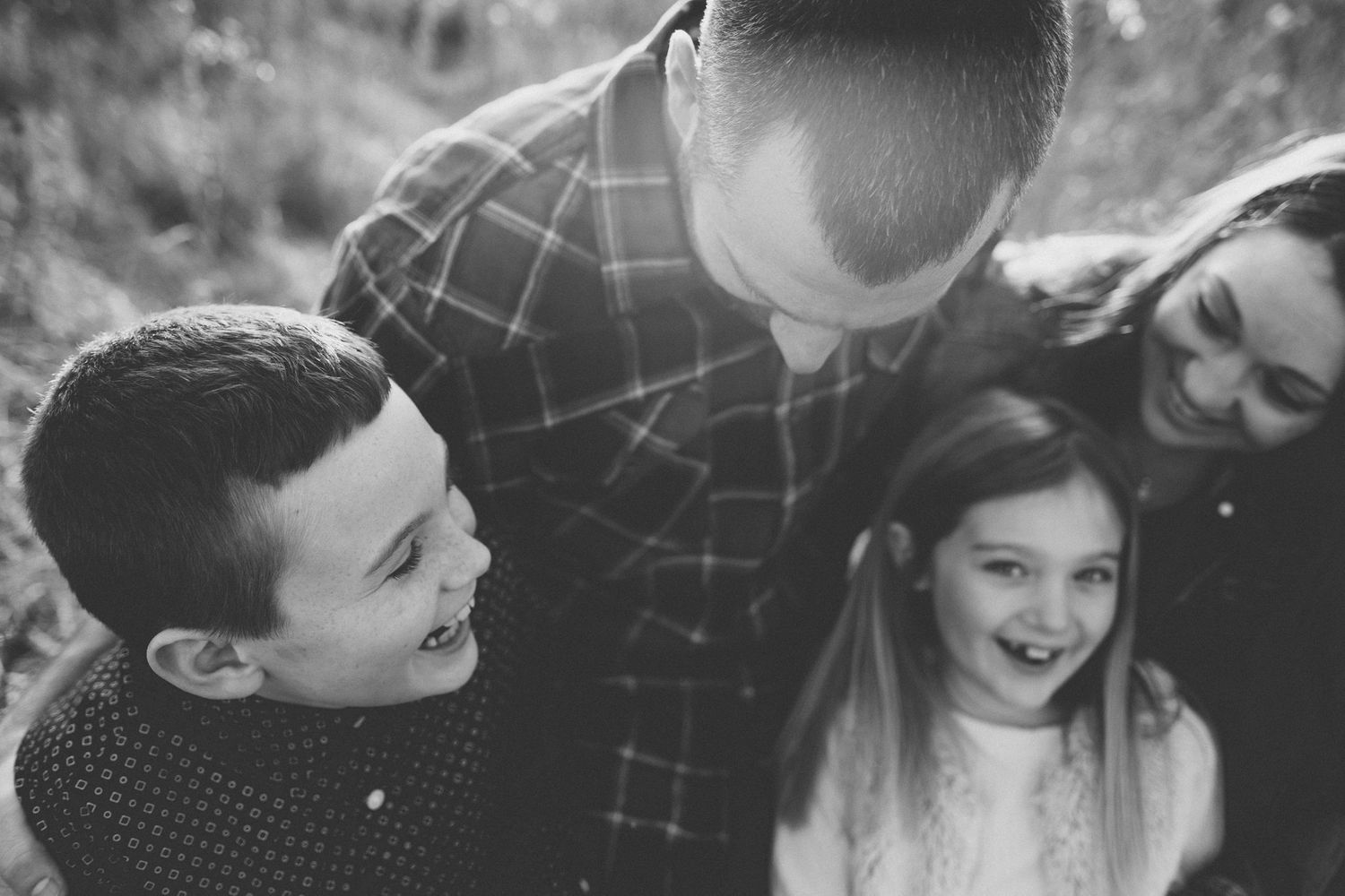 Black and white portrait of family sharing loving moment outdoors.