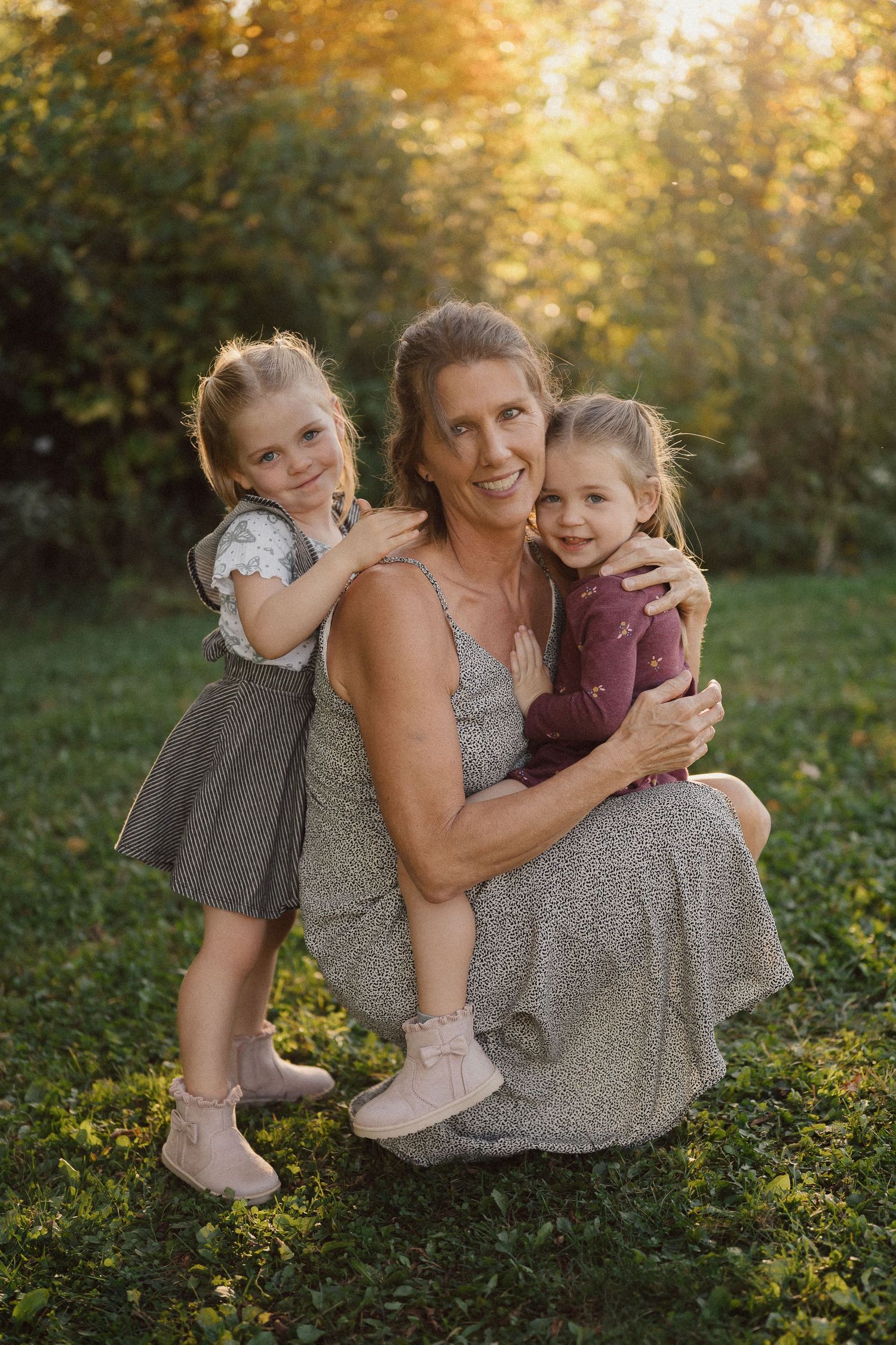 A tender outdoor photoshoot in golden sunlight shows warm embraces and playful moments in a natural setting.